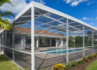 Large white aluminum pool cage screen enclosure over a pool in a South Florida backyard