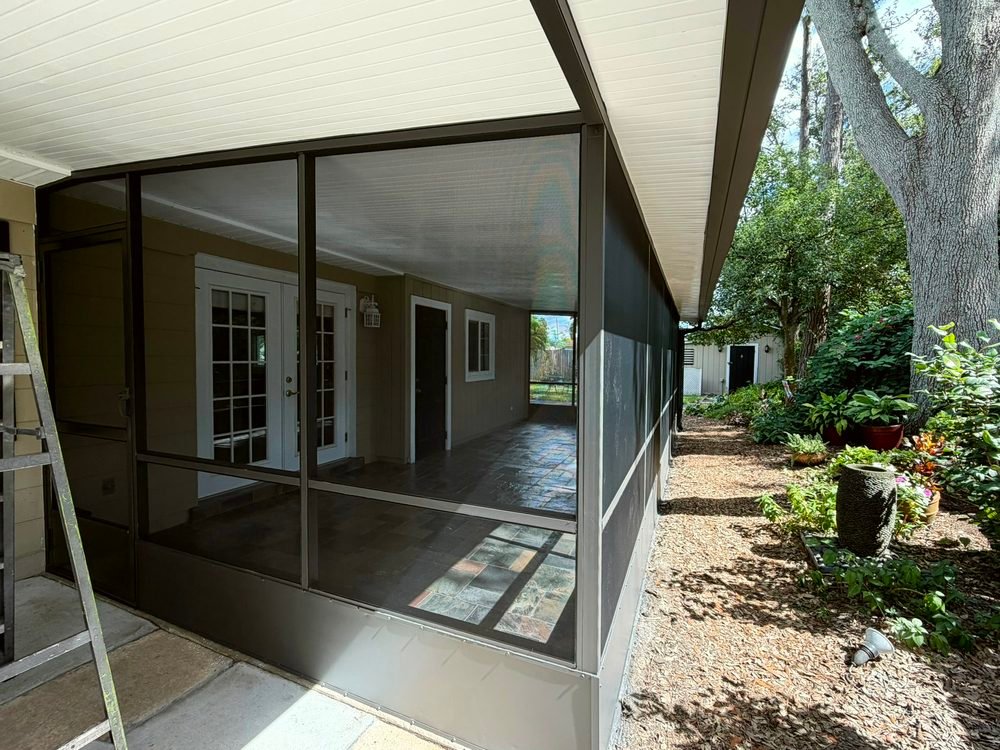 The same screen porch after repainting, with a dark bronze aluminum frame and new screen