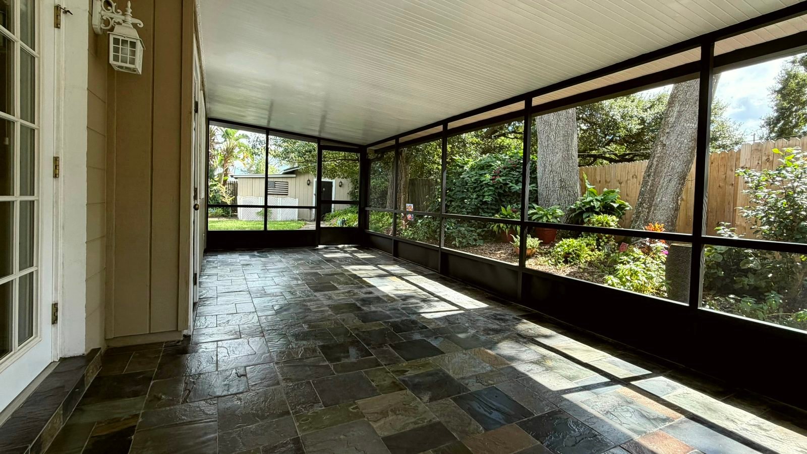 Screen porch with a newly painted dark bronze aluminum frame, new screens and a slate tile floor